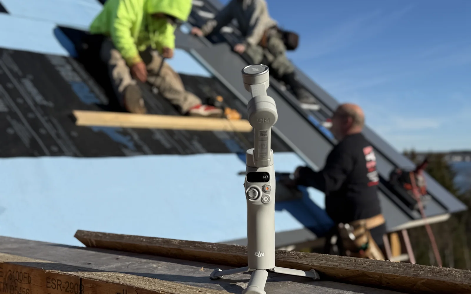 Camera filming contractors working on a roof for project photo content