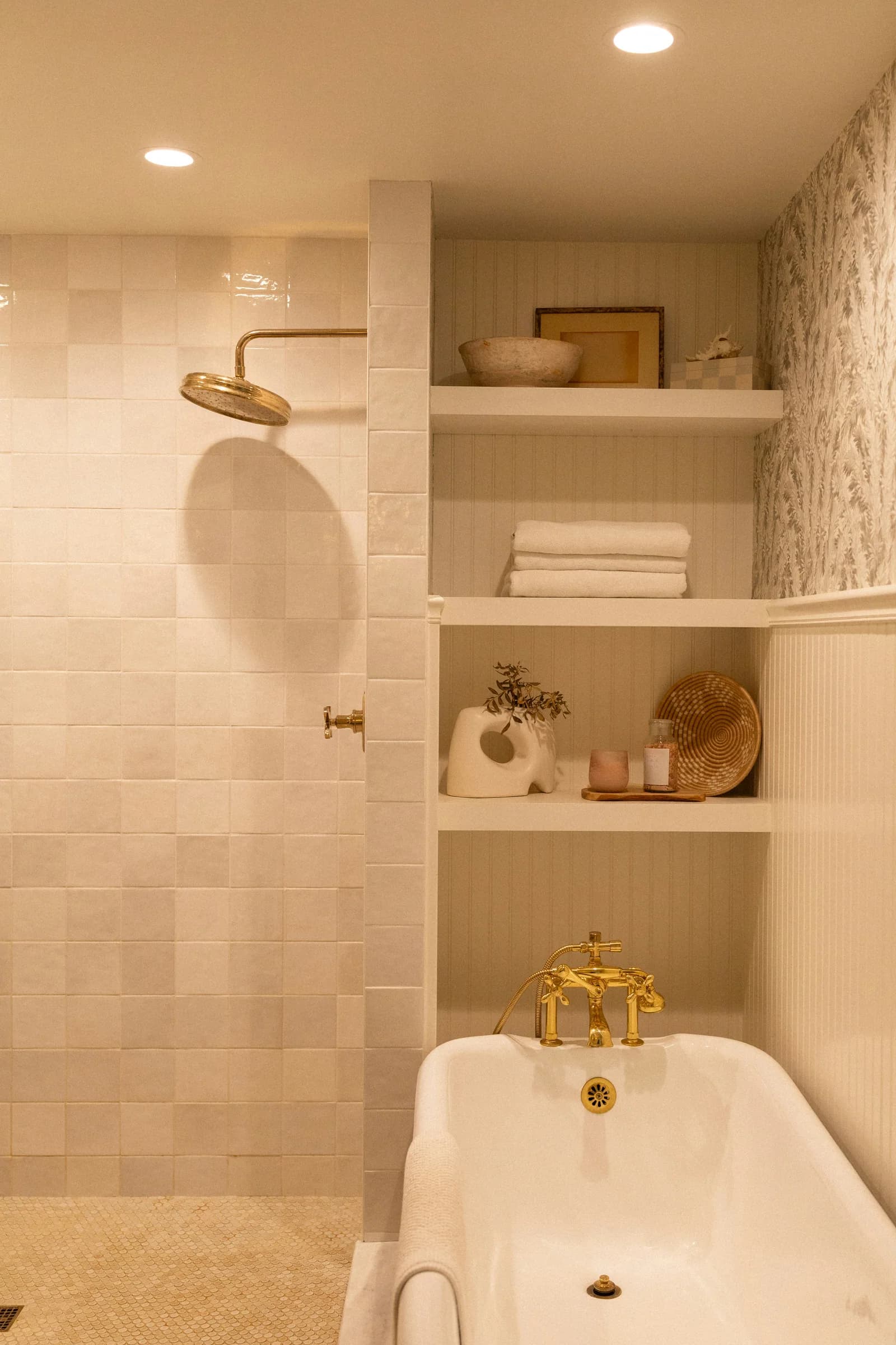 Bathroom with arched shelving beside a freestanding tub