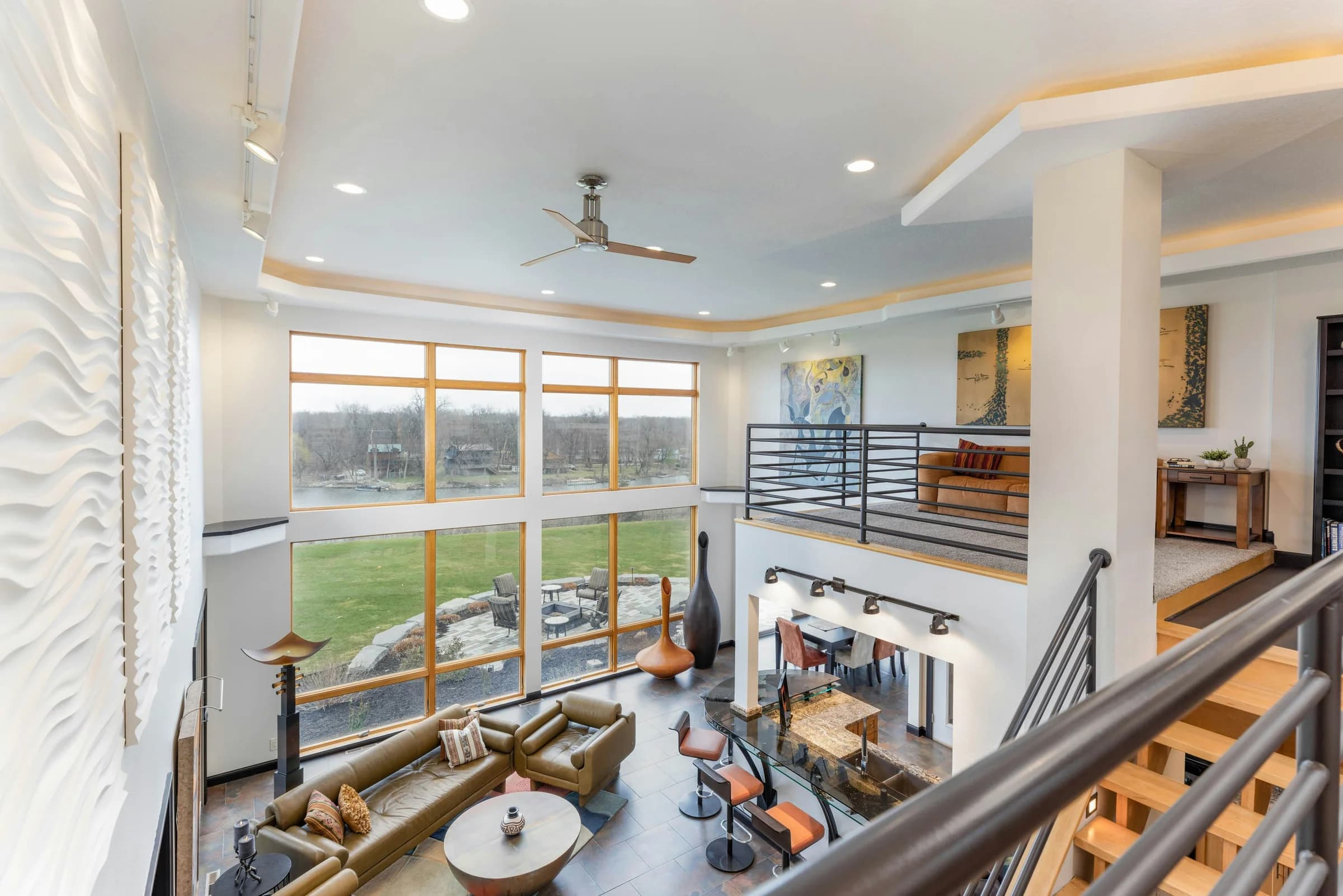 Double-height living room with tall windows and an open oak mezzanine