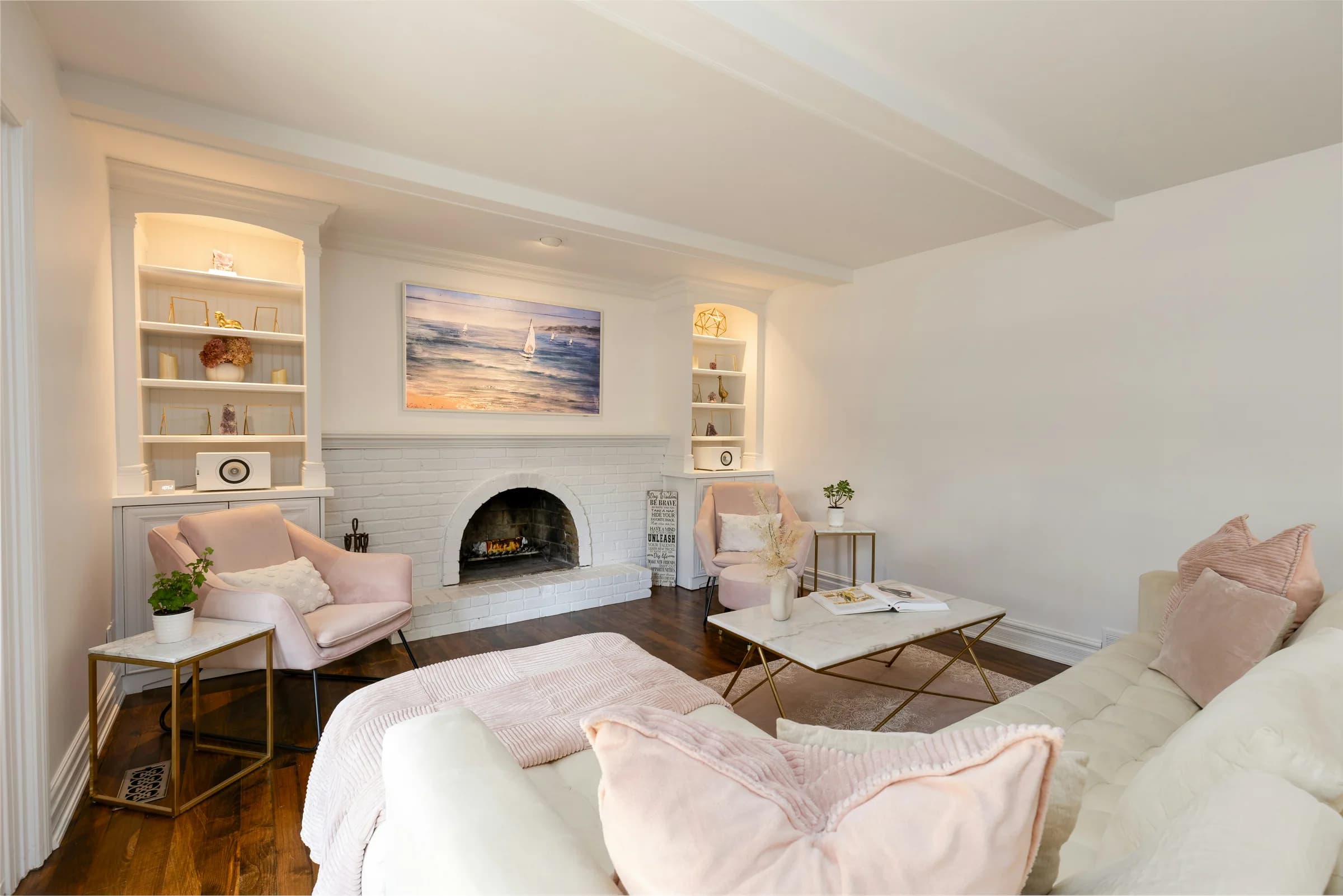 Softly furnished living room with an arched fireplace and built-in shelves