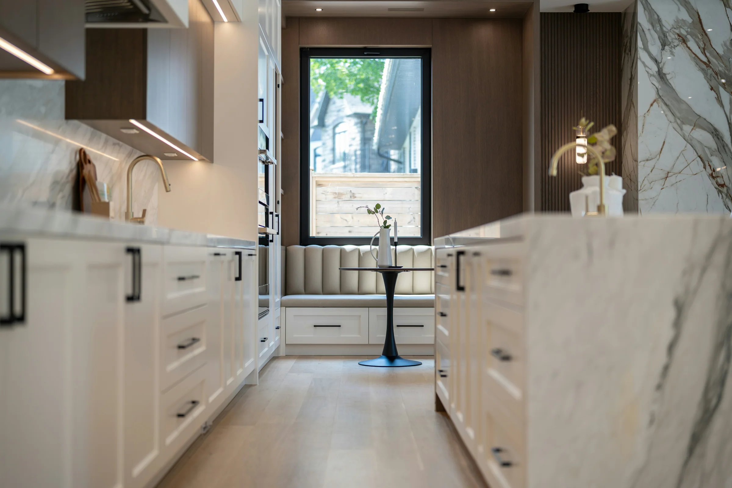Veined marble waterfall island and finely detailed kitchen cabinetry