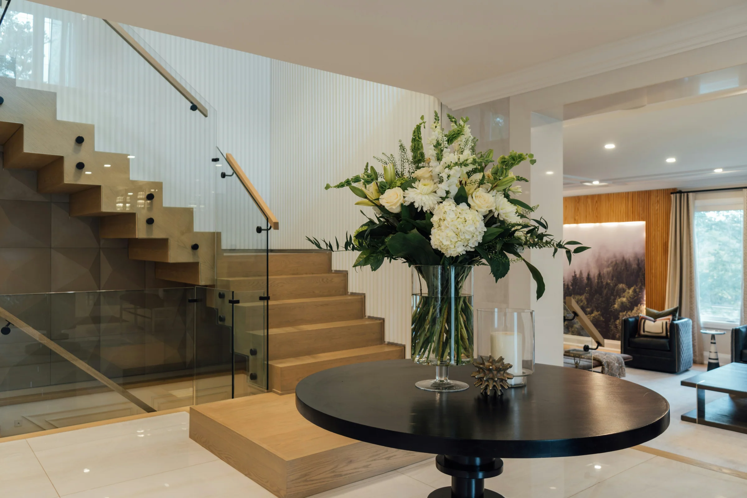 Oak staircase and a round entry table with fresh flowers