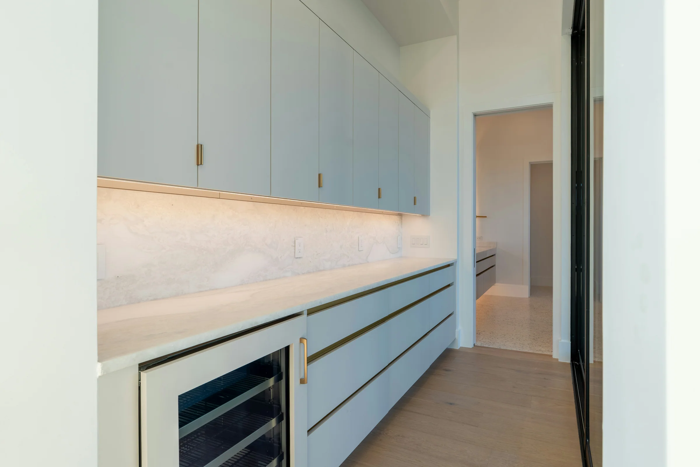 Sage pantry cabinetry with a stone counter and built-in drinks fridge