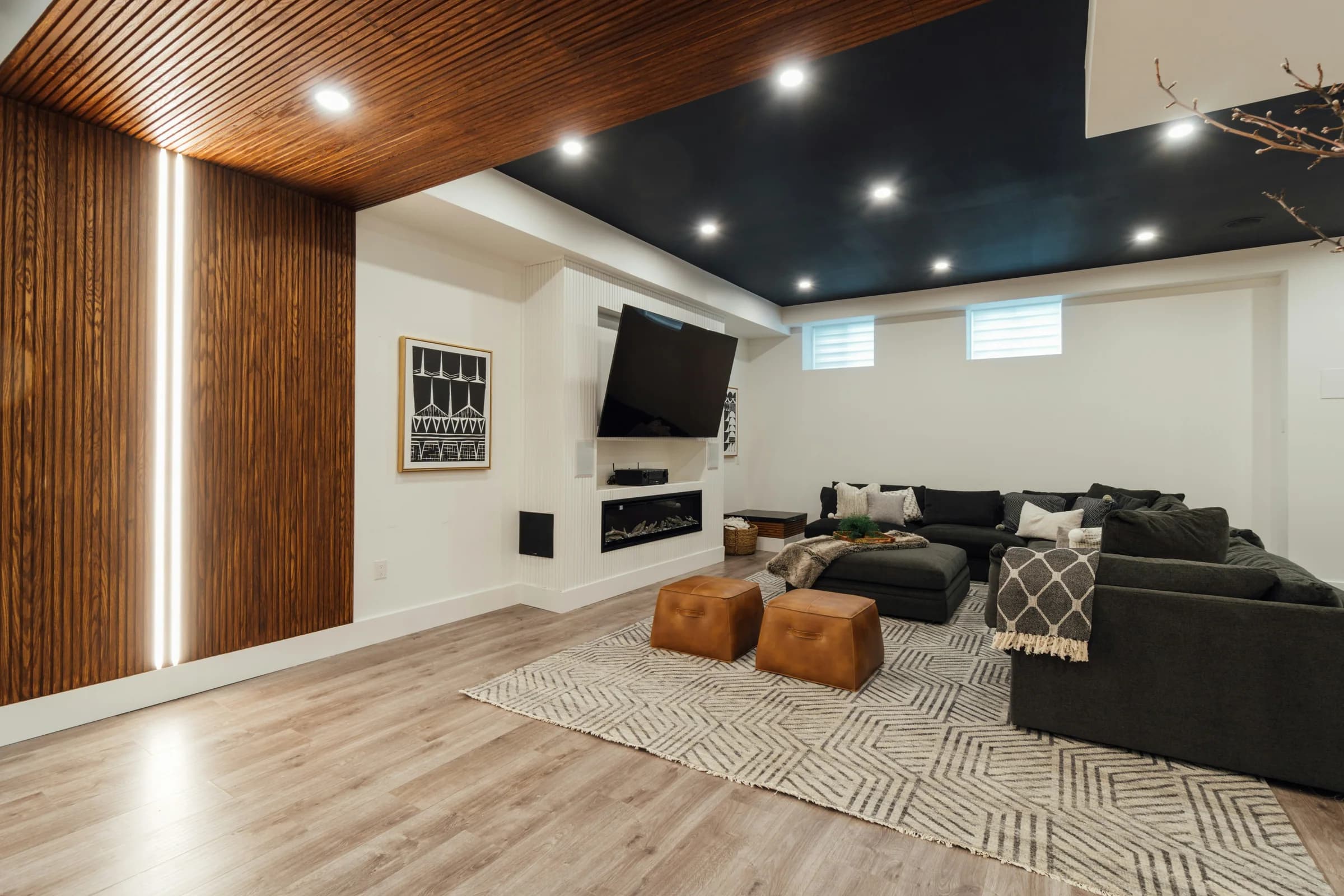 Media room with a timber ceiling and dark sectional sofa