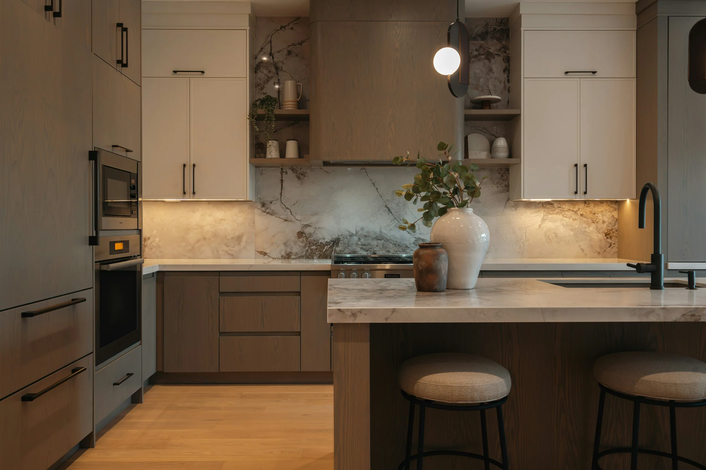 Warm walnut kitchen with a marble backsplash and island seating