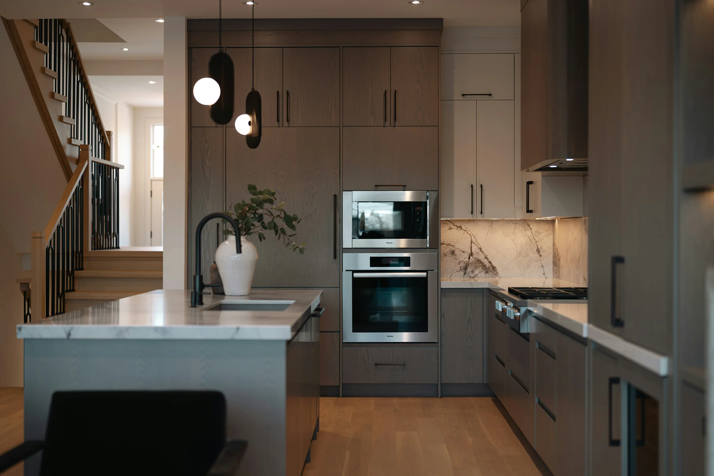 Walnut kitchen with a stone island and globe pendant lights